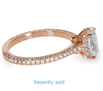 Anillo de compromiso de halo secreto con incrustaciones de diamantes en oro rosa.